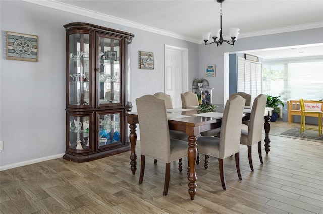 dining room with baseboards, crown molding, a chandelier, and wood finished floors