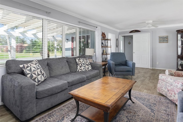 living area featuring ornamental molding, plenty of natural light, baseboards, and wood finished floors