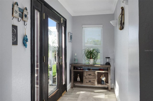 interior space with light wood finished floors, ornamental molding, and baseboards