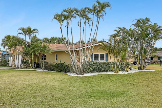 view of front facade featuring stucco siding and a front yard