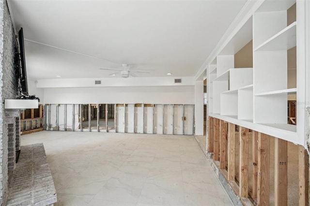 unfurnished room featuring a ceiling fan, visible vents, and a brick fireplace