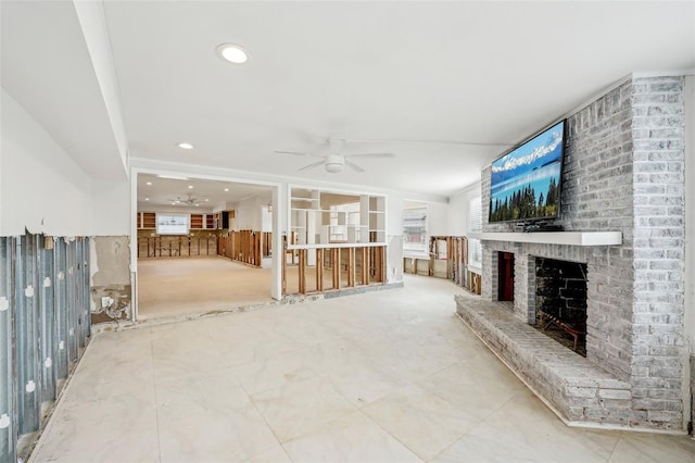 unfurnished living room featuring a ceiling fan, a brick fireplace, and recessed lighting