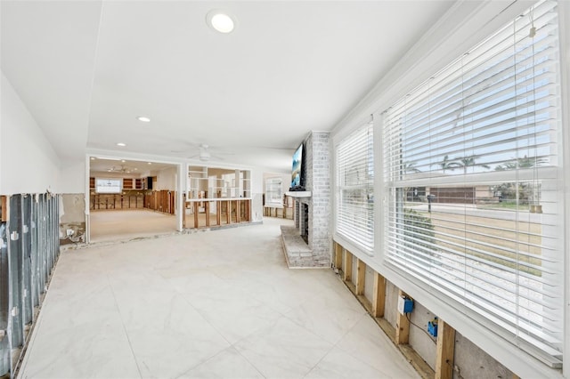 interior space featuring a brick fireplace and ceiling fan