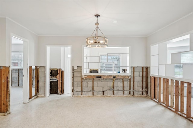 unfurnished dining area with crown molding and a chandelier