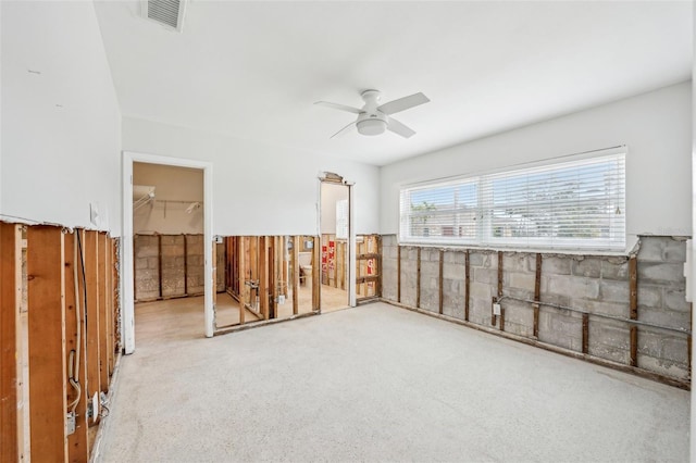 carpeted spare room with a ceiling fan and visible vents