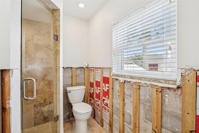 full bathroom featuring a shower stall, toilet, and tile walls