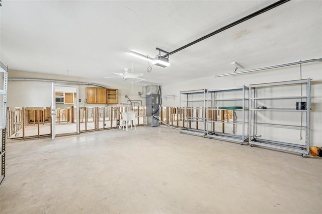 garage with a garage door opener, heating unit, and a sink