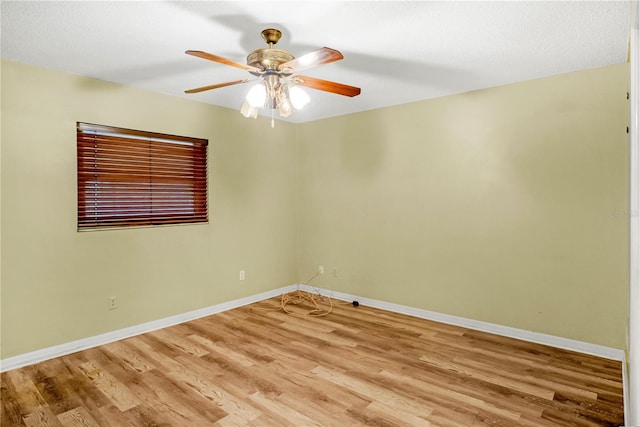 empty room featuring light wood-style floors, baseboards, and a ceiling fan