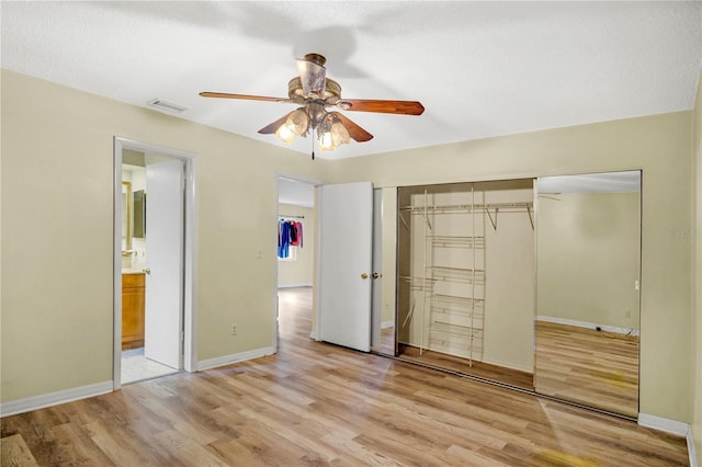 unfurnished bedroom featuring a closet, visible vents, baseboards, and light wood finished floors