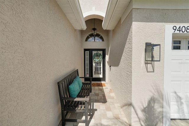 view of exterior entry featuring stucco siding and a garage