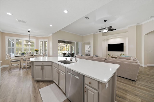 kitchen with visible vents, a sink, stainless steel dishwasher, light wood-style floors, and light countertops