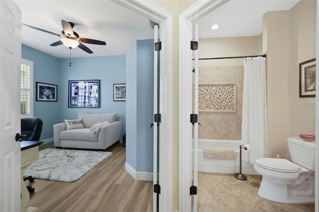 full bathroom with a ceiling fan, wood finished floors, baseboards, shower / bath combo with shower curtain, and toilet