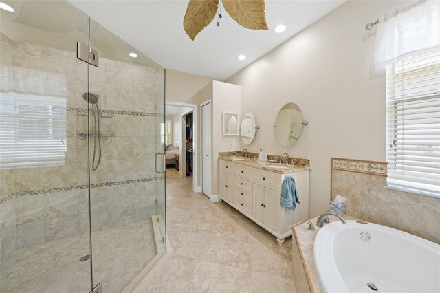 bathroom with double vanity, a sink, a shower stall, vaulted ceiling, and a garden tub