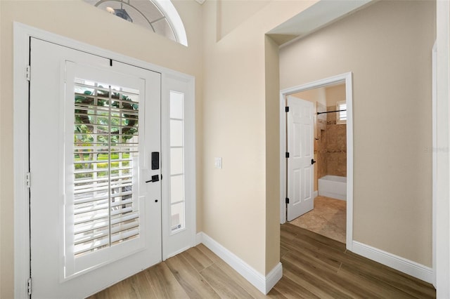 foyer entrance with wood finished floors and baseboards