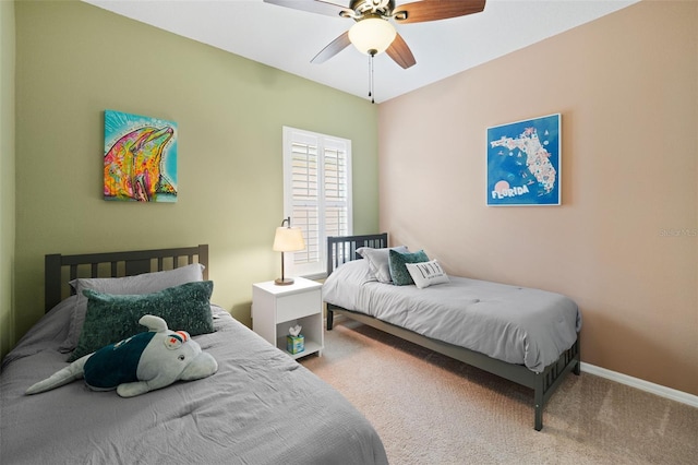 carpeted bedroom with a ceiling fan and baseboards