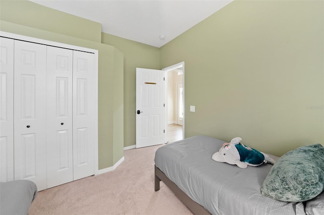 carpeted bedroom featuring a closet and baseboards