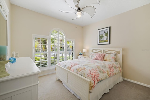 bedroom with multiple windows, baseboards, and light carpet