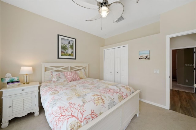 carpeted bedroom featuring a ceiling fan, baseboards, visible vents, and a closet