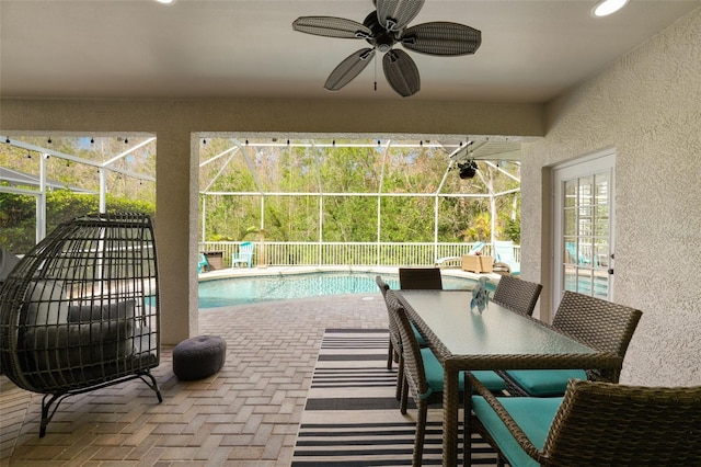 view of swimming pool with a patio area, a fenced in pool, a lanai, and a ceiling fan