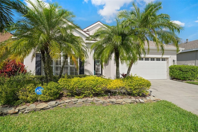 obstructed view of property featuring stucco siding, a garage, and driveway