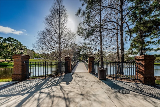 view of gate with a water view and fence