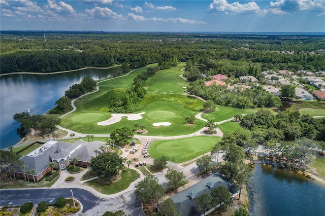 birds eye view of property featuring a forest view, a water view, and view of golf course