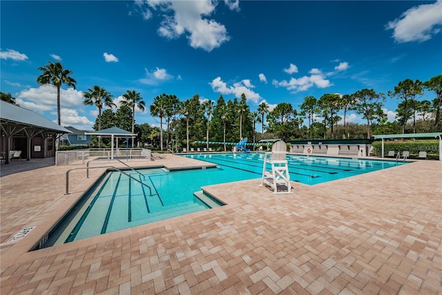 pool with a patio area and fence