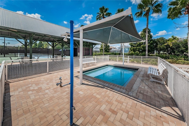 view of swimming pool with a patio and fence