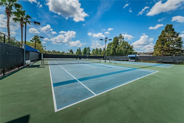 view of tennis court featuring fence