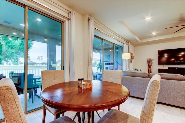 dining space with light tile patterned flooring and a ceiling fan