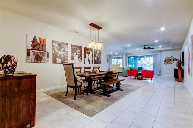 dining room featuring light tile patterned floors, visible vents, baseboards, and ceiling fan with notable chandelier