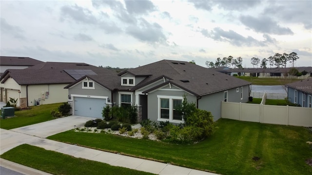 view of front of home featuring a garage, a residential view, driveway, and a front lawn