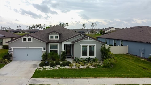 craftsman-style home with fence, driveway, a front lawn, a garage, and a residential view