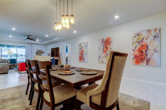 dining room featuring ceiling fan with notable chandelier, a tray ceiling, light tile patterned floors, and recessed lighting