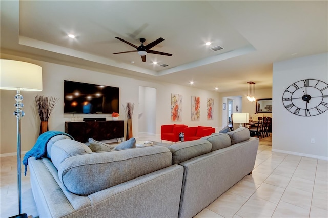 living room featuring recessed lighting, a tray ceiling, visible vents, and ceiling fan