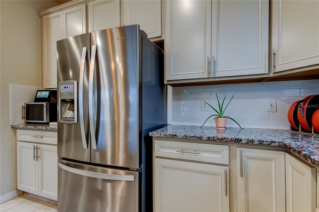 kitchen with light stone counters, backsplash, and appliances with stainless steel finishes