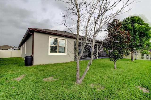 view of home's exterior with a lawn, a fenced backyard, and stucco siding