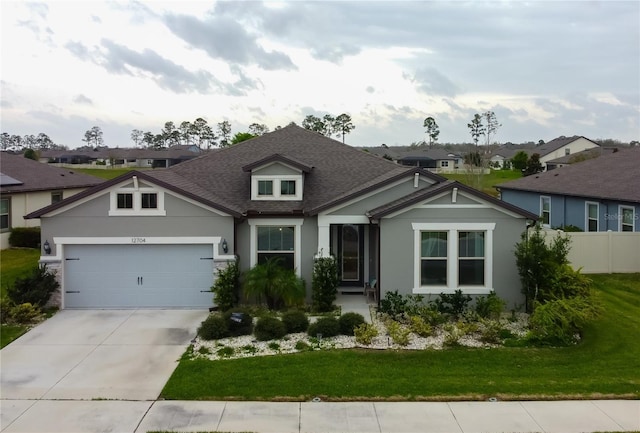 view of front of house featuring fence, a residential view, concrete driveway, a front yard, and a garage