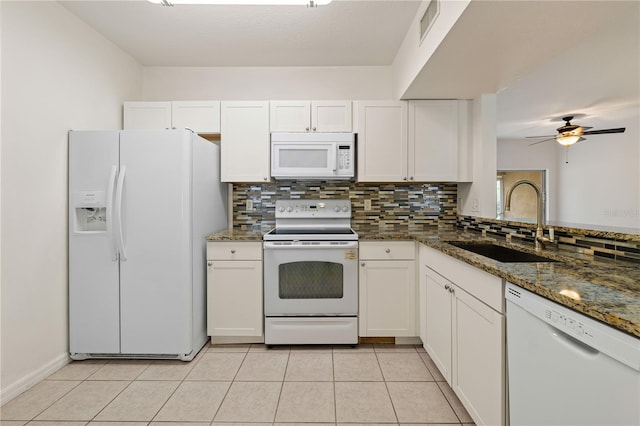 kitchen with white appliances, visible vents, dark stone counters, white cabinetry, and a sink