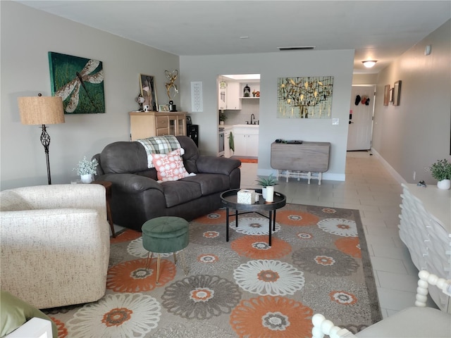 living area featuring visible vents, baseboards, and light tile patterned floors