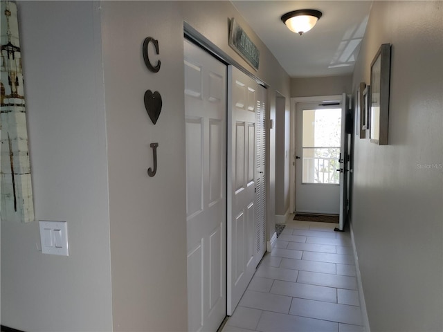 entryway with baseboards and light tile patterned floors