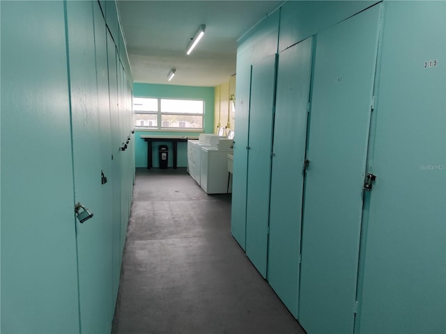 hall with concrete flooring and washing machine and dryer