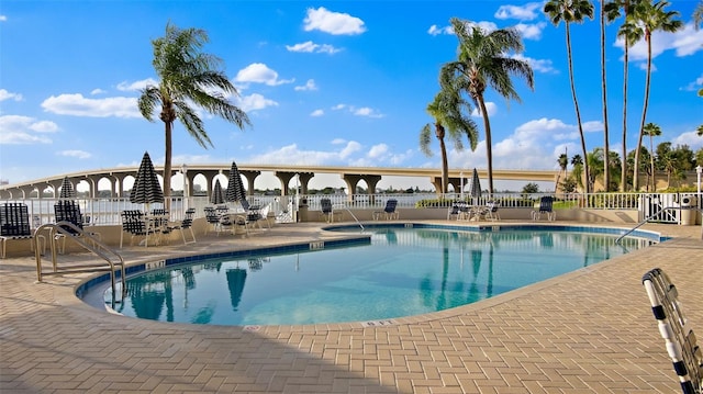 community pool featuring fence and a patio