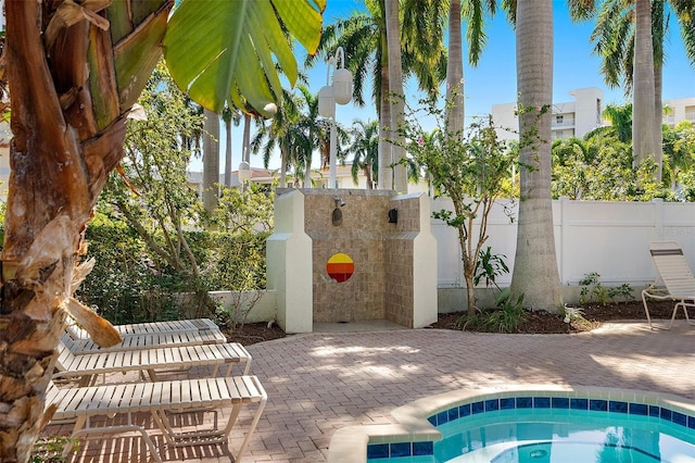 view of pool featuring an in ground hot tub, fence, and a patio