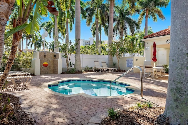 view of pool featuring a community hot tub, outdoor dining area, a patio area, and fence