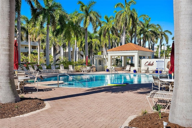 pool with a patio area and fence