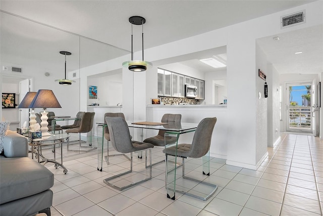 dining space featuring baseboards, visible vents, and light tile patterned flooring