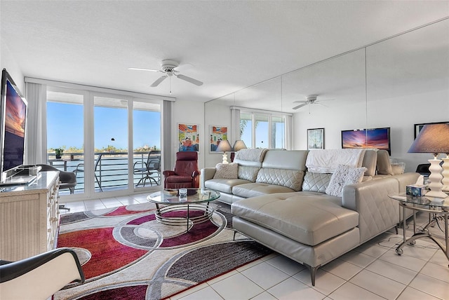 living area featuring ceiling fan, a textured ceiling, and light tile patterned floors