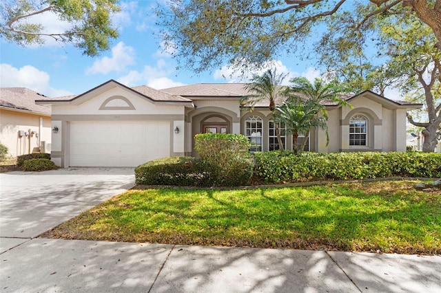 ranch-style home with driveway, an attached garage, a front lawn, and stucco siding