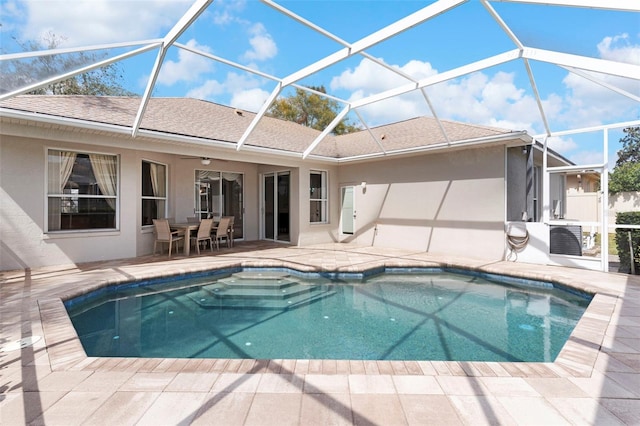 outdoor pool featuring cooling unit, glass enclosure, and a patio area